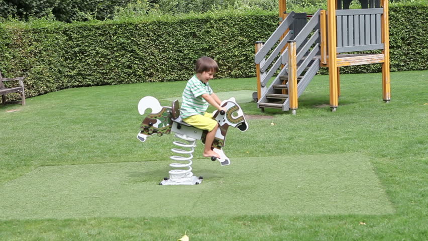 cute-little-boy-swinging-on-the-playground-summertime-rocking-back