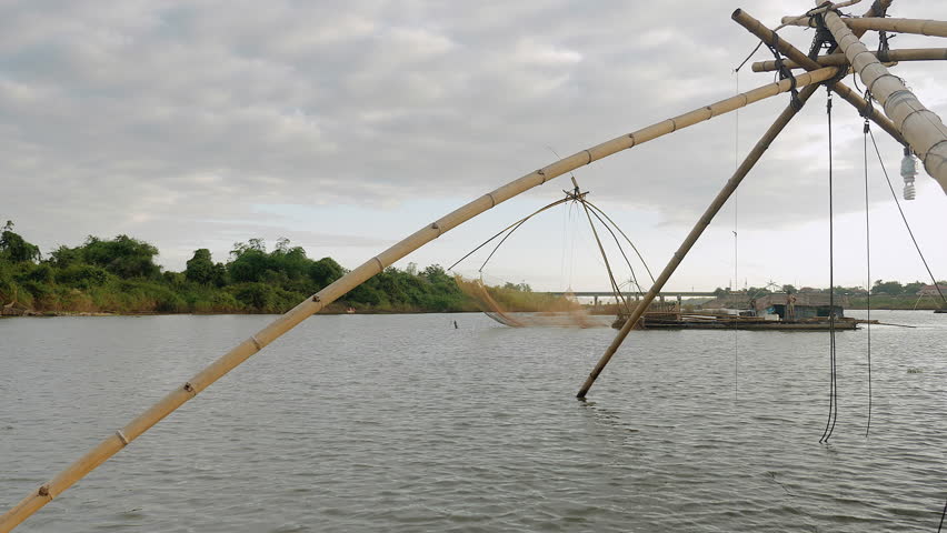 Houseboat with chinese fishing net moving slowly on lake - 4K stock video clip
