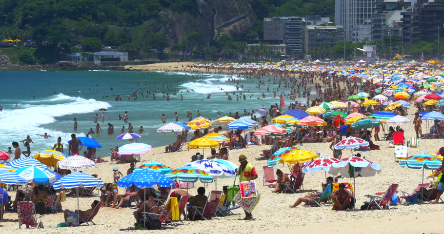 Sunbathers Lie In The Sand Of Copacabana Beach In Rio De Janeiro
