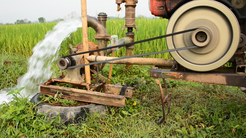 water-pump-machine-for-agriculture-is-working-to-the-rice-field-stock