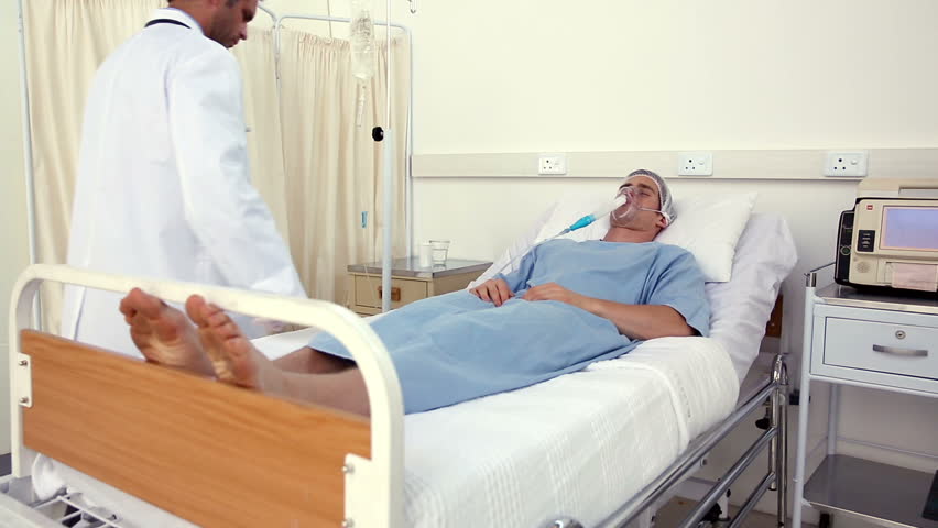 Doctor Checking Patient In Bed With An Oxygen Mask In The Hospital ...