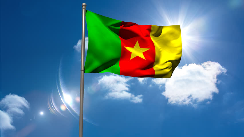Cameroon National Flag Waving On Flagpole On Blue Sky Background Stock