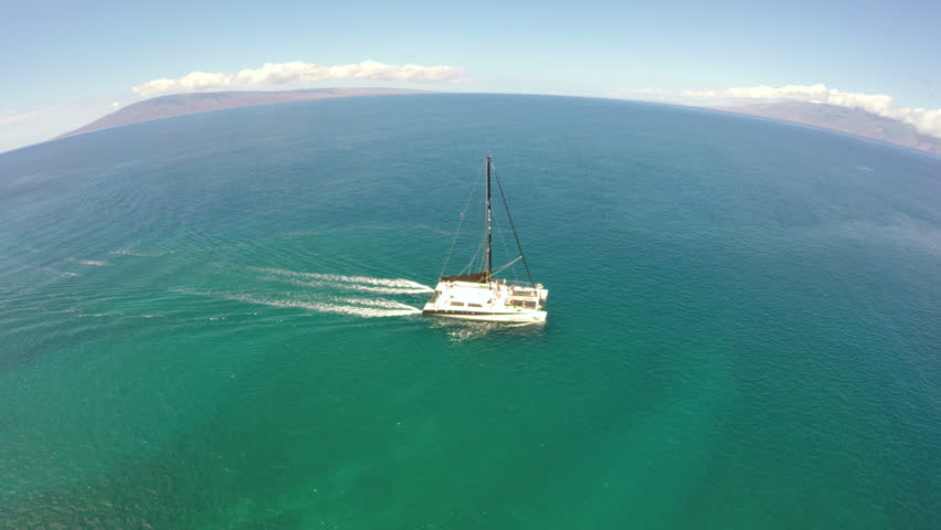 Aerial Chase Footage Of A Catamaran Sailboat On Crystal Clear Seas In 