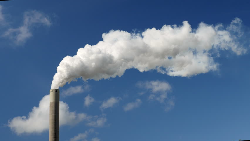 Medium shot of a smoke stack with a thick smoke plume. Beautiful blue ...