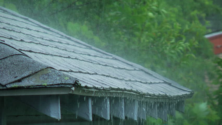 Heavy rain falling on the edge of a roof. - HD stock footage clip