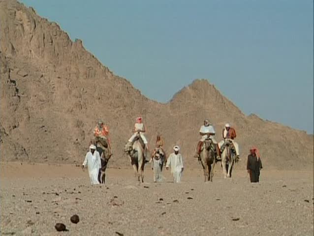 Egyptian People Walking Through The Desert And Riding A Camel Stock ...