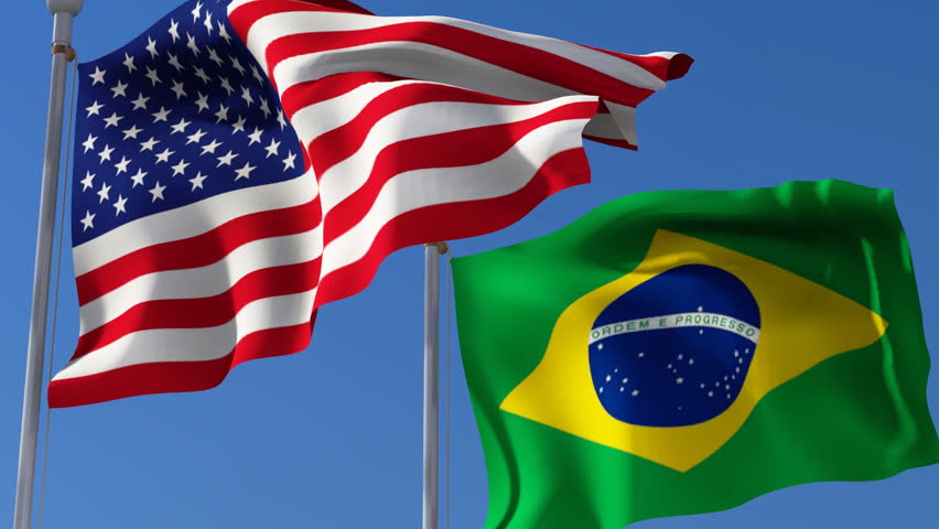 Flag Of Usa And Brazil Waving In The Wind Against Blue Sky. Three ...