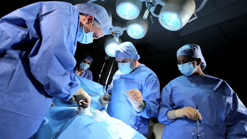 Male Female Surgical Team In Protective Clothing Performing Surgery ...