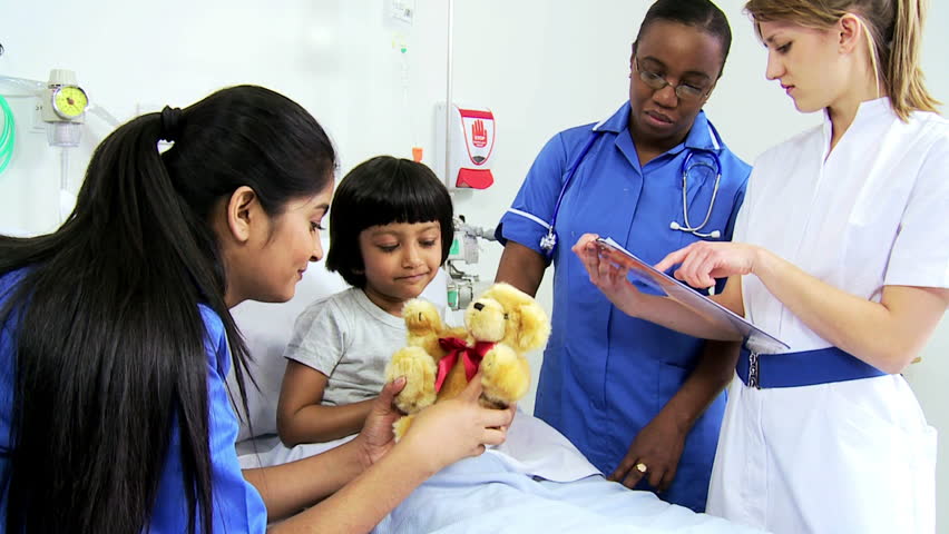 Multi-ethnic Nursing Staff Provides Bedside Support To A Cute Young ...