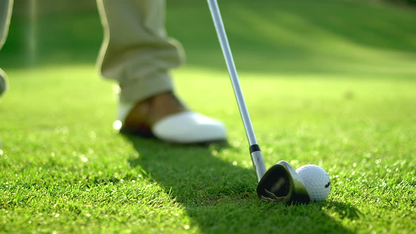 Close Up Of A Golf Ball Being Hit By A Club On The Grass, In Slow ...